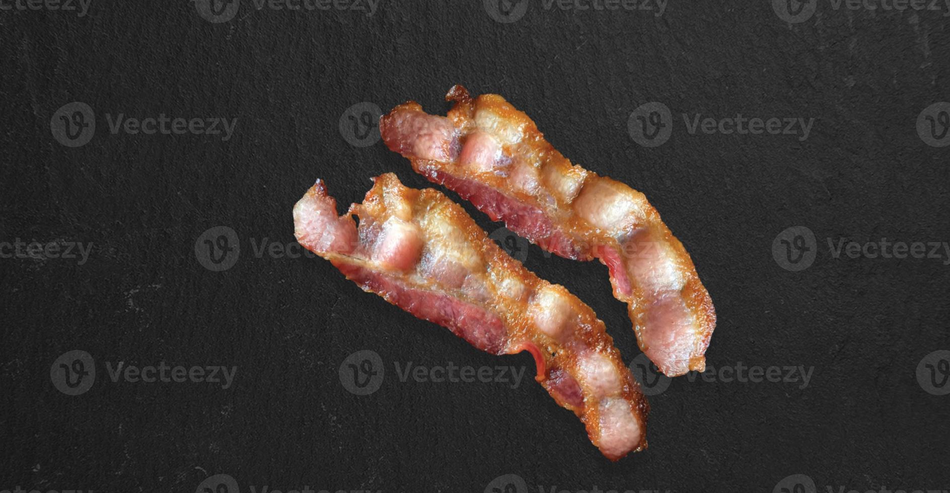 tranches de bacon fumé à coupe épaisse et croustillantes isolées sur fond sombre, vue rapprochée adaptée au projet de conception de produits alimentaires. photo