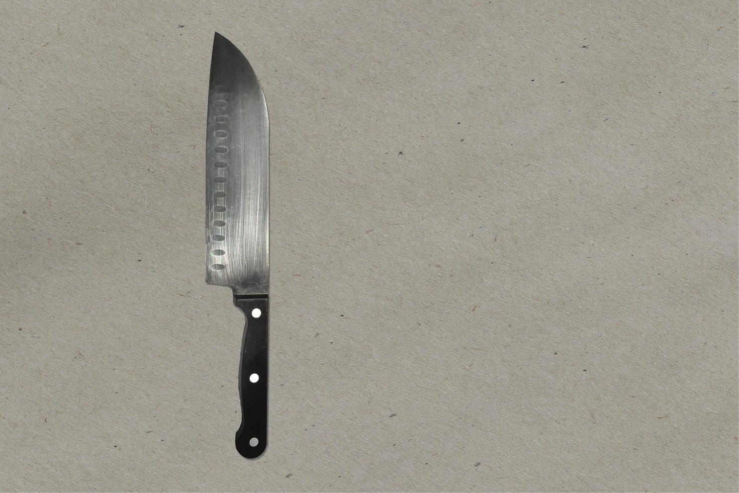vue rapprochée couteau métallique pointu brillant isolé sur une table de cuisine blanche. adapté à votre projet de conception. photo