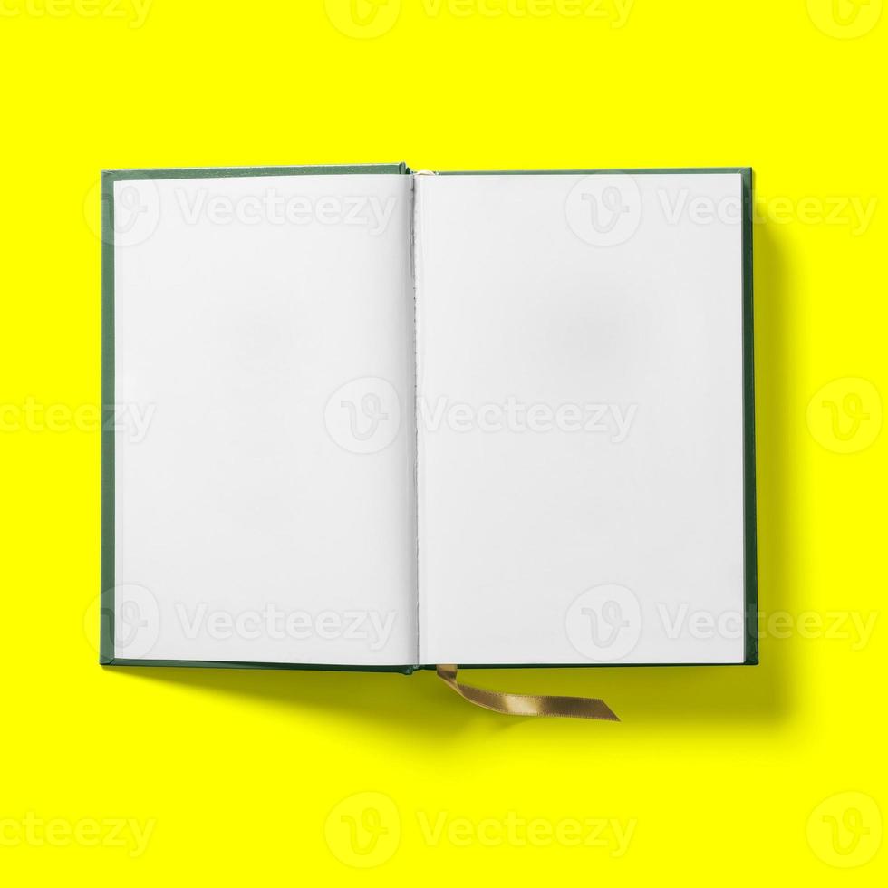 concept de retour à l'école, première page de livre vert foncé à couverture rigide ouverte isolée sur jaune. photo