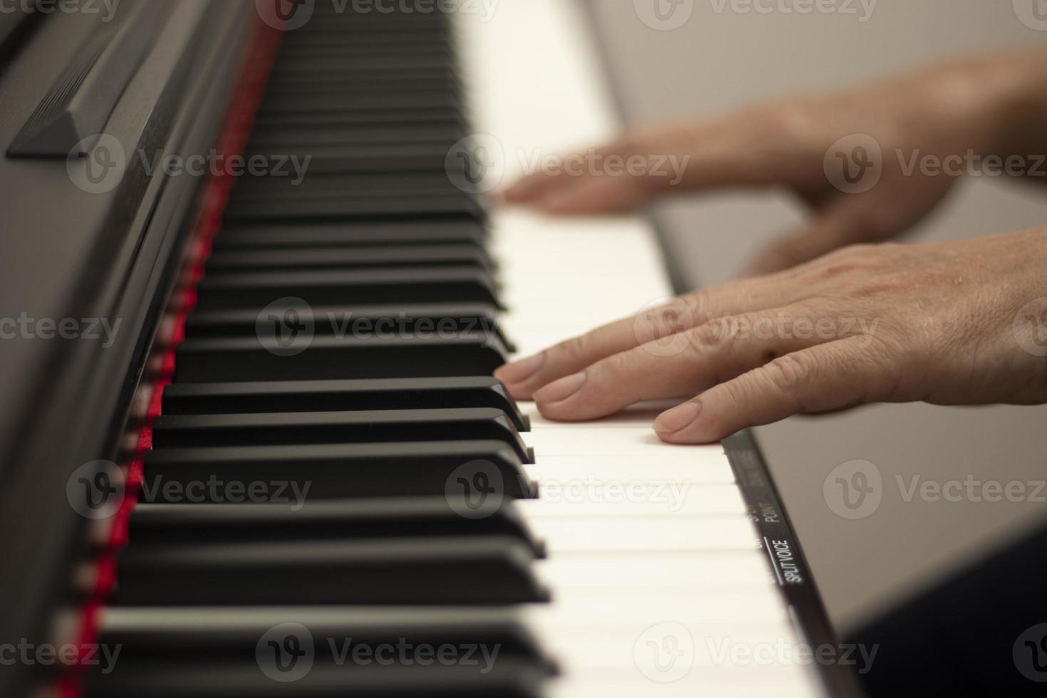 des mains féminines jouent du piano électrique, des touches de main et de piano se bouchent photo