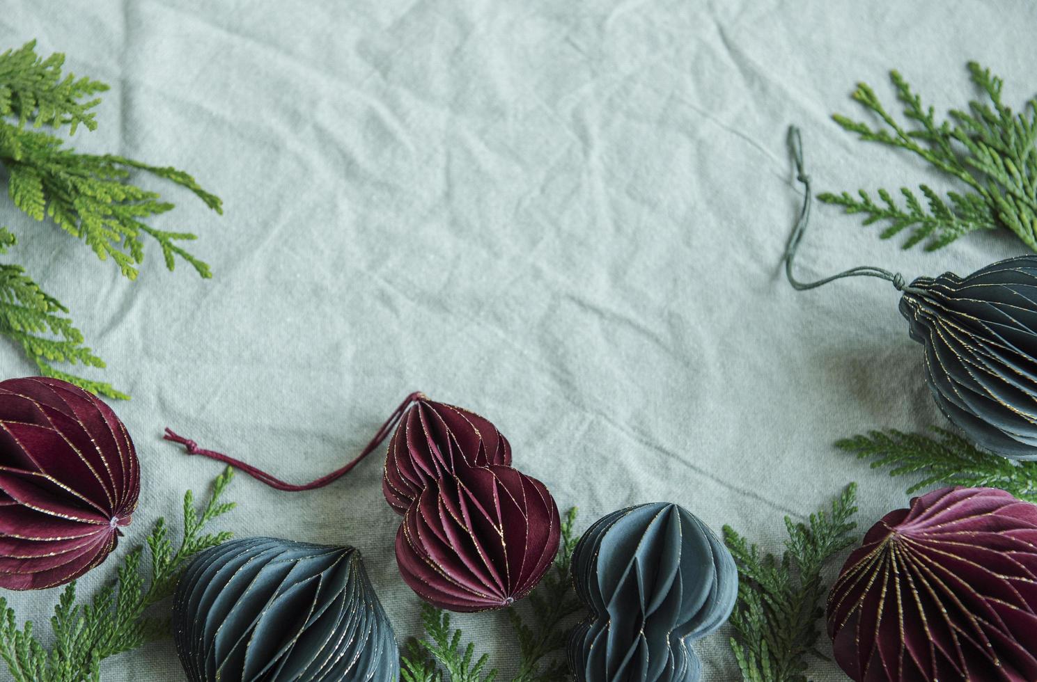 brindilles d'épinette avec des décorations en papier sur le fond textile chiffonné en lin vert photo