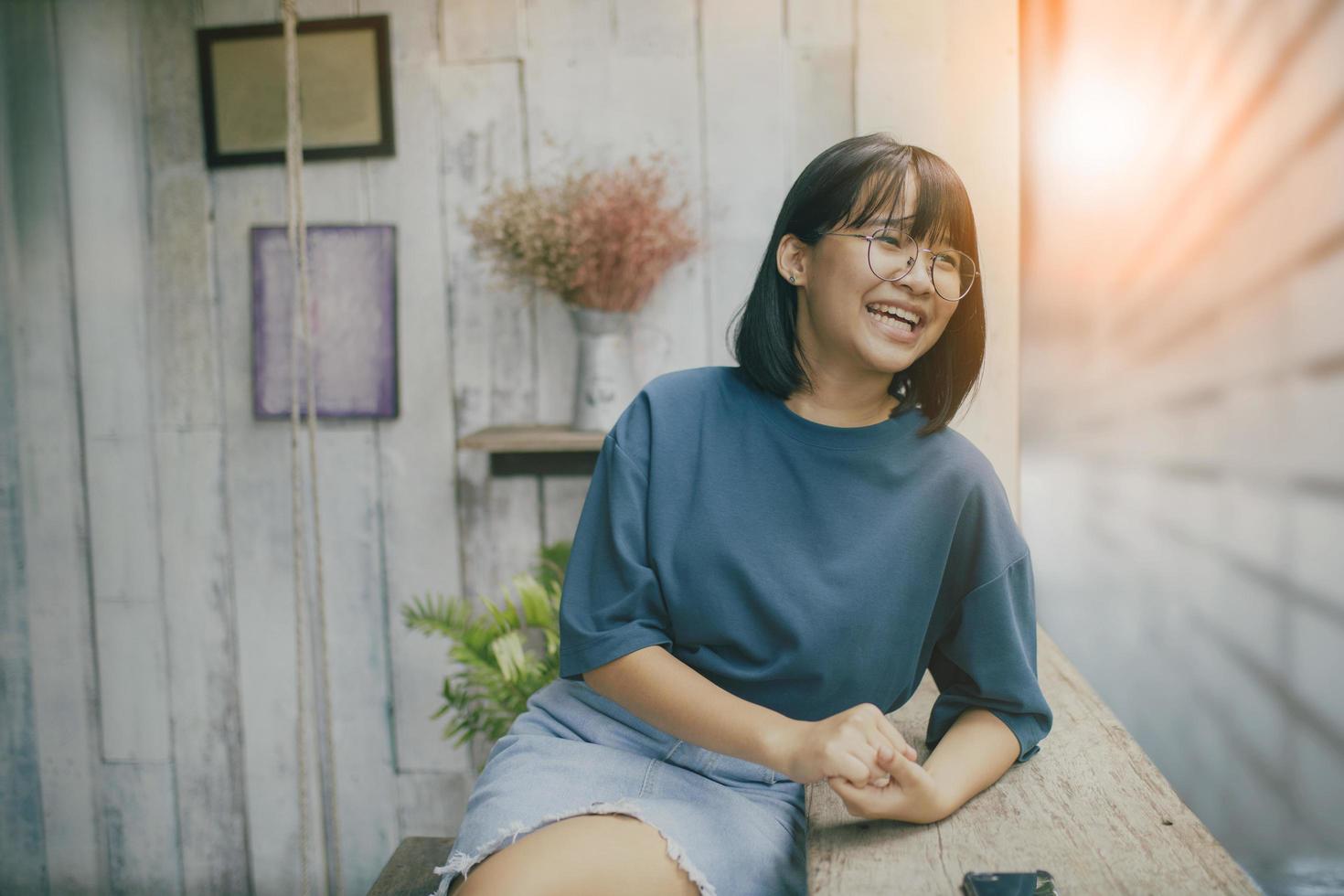 adolescent asiatique riant de bonheur face au café vivant photo