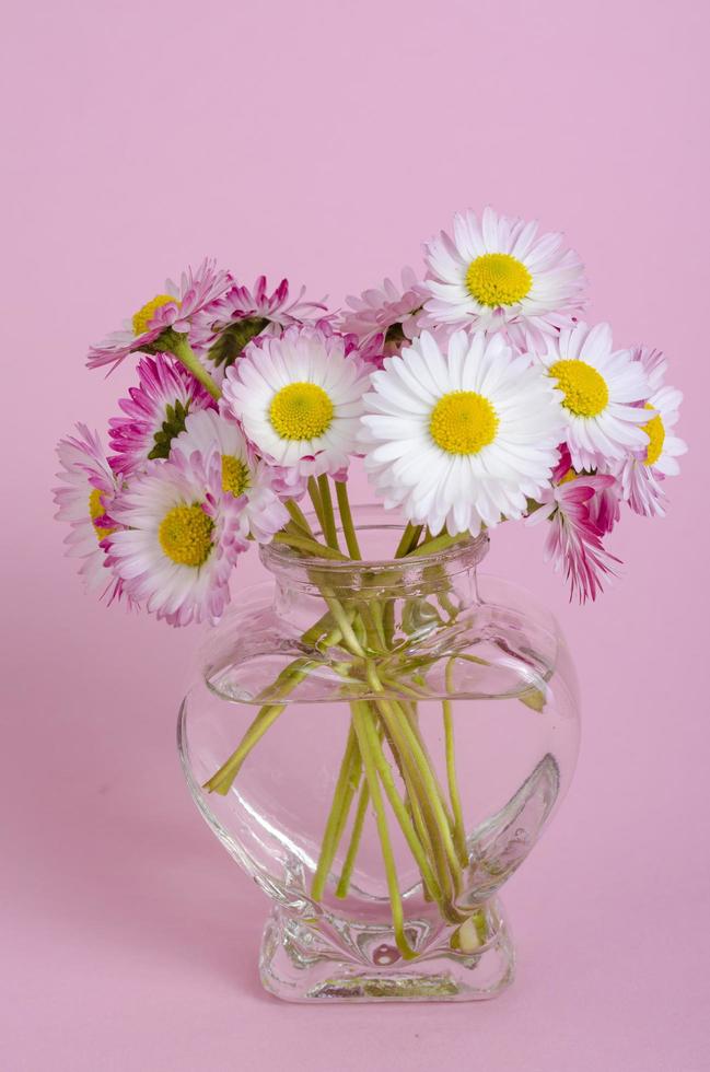 fond rose pour carte de saint valentin, vase avec des fleurs en forme de coeur. photo