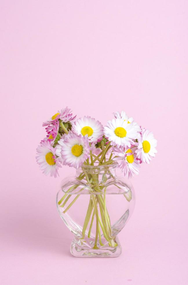 fond rose pour carte de saint valentin, vase avec des fleurs en forme de coeur. photo