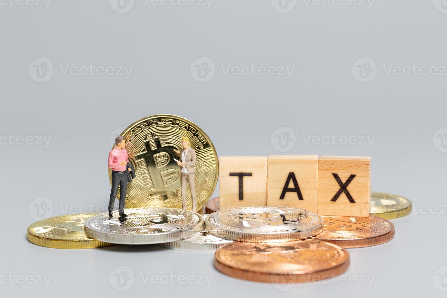 personnes miniatures, homme d'affaires avec crypto-monnaie et taxe sur les lettres en bois photo