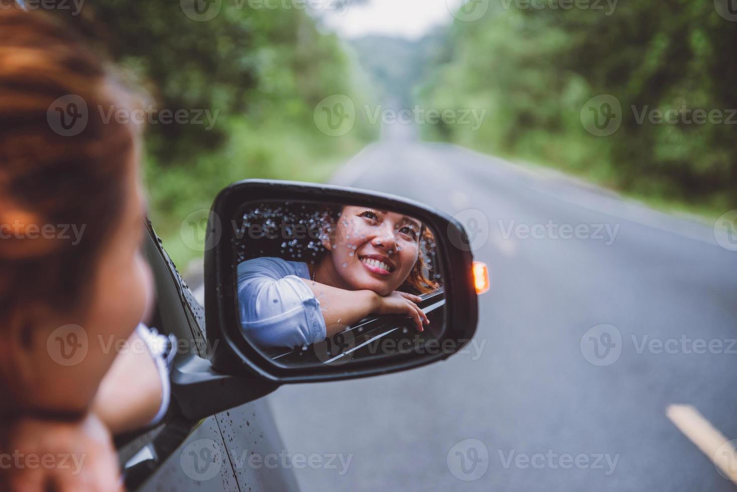 les femmes asiatiques voyagent se détendent pendant les vacances. voyager en parking. heureusement avec la nature, forêt rurale. en été. femme au volant d'une voiture voyageant heureusement. photo