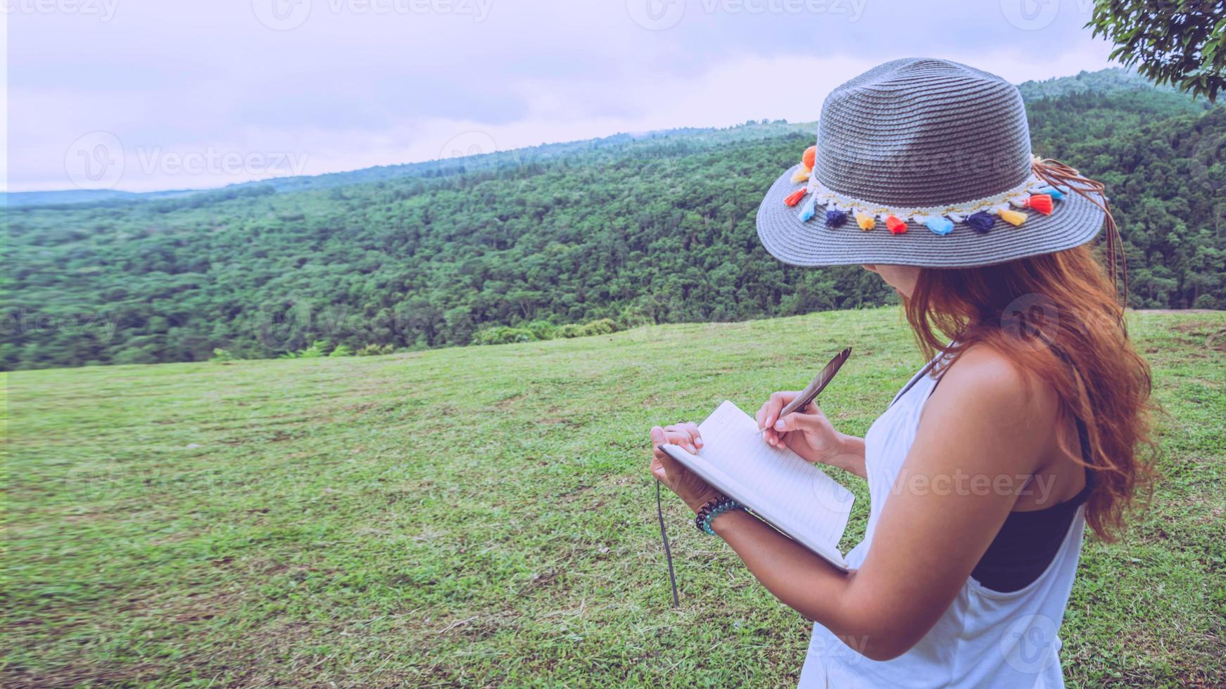 les femmes asiatiques se détendent pendant les vacances. stand écrire le record sur les prairies du parc. photo