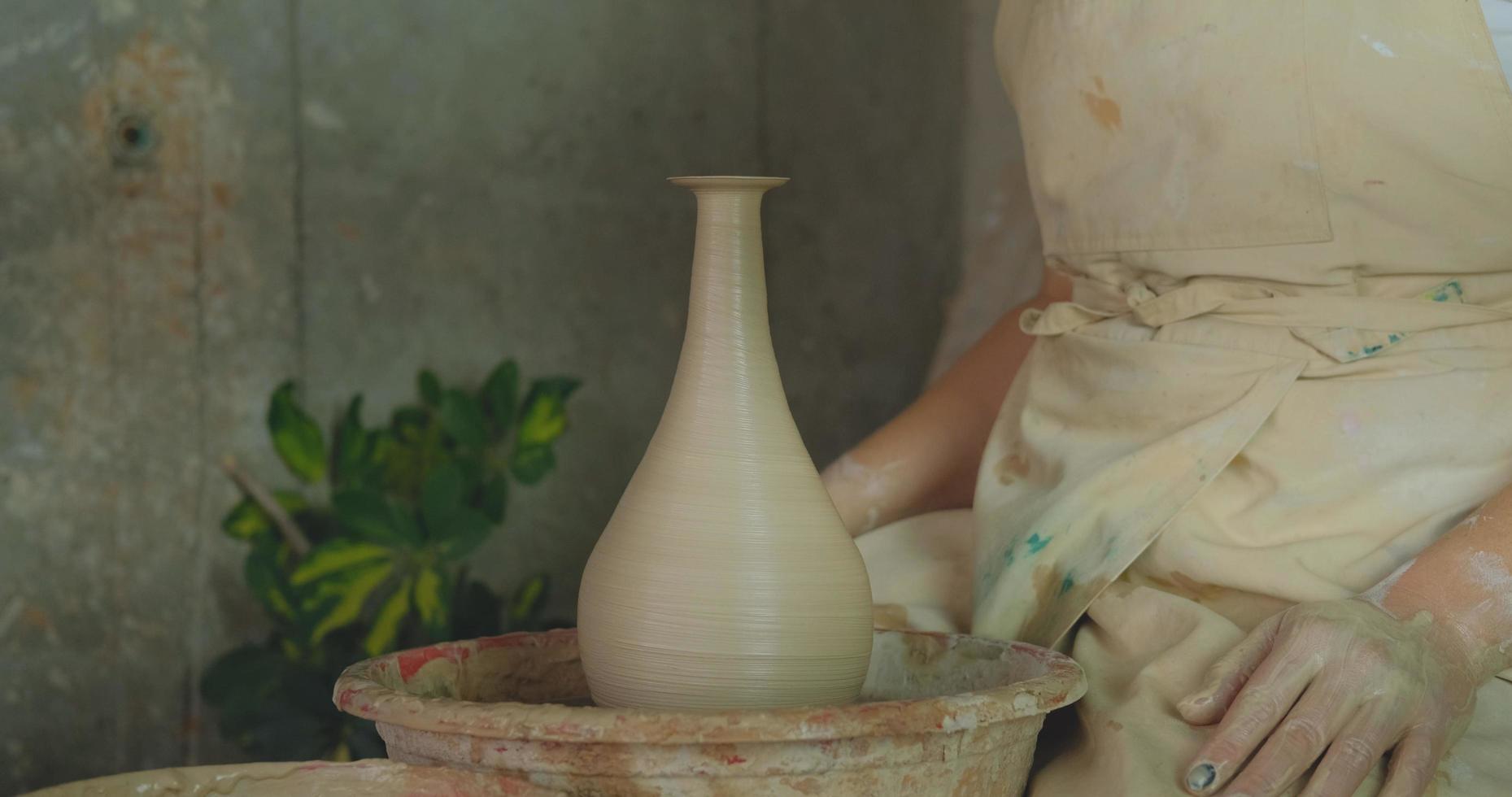 Close up of womans travail à la main avec de l'argile en studio de poterie photo