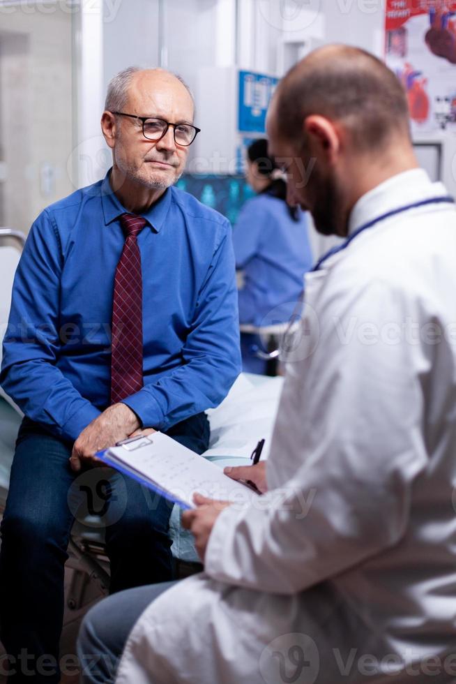 vieil homme répondant au questionnaire du médecin photo