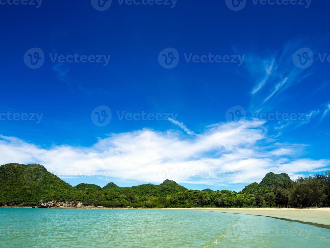 large vue sur la plage, la mer et la montagne avec un ciel bleu photo
