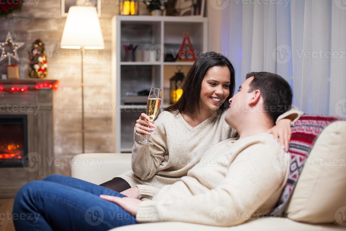 couple détendu assis sur un canapé célébrant le jour de noël photo