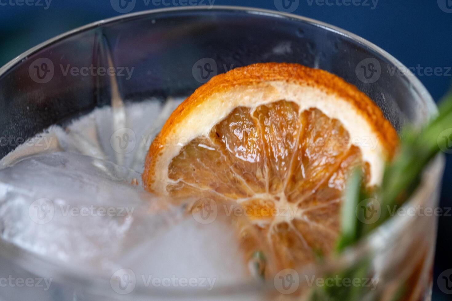 verre de Gin Tonique cocktail avec glace, brin de Romarin et tranché sec Orange photo