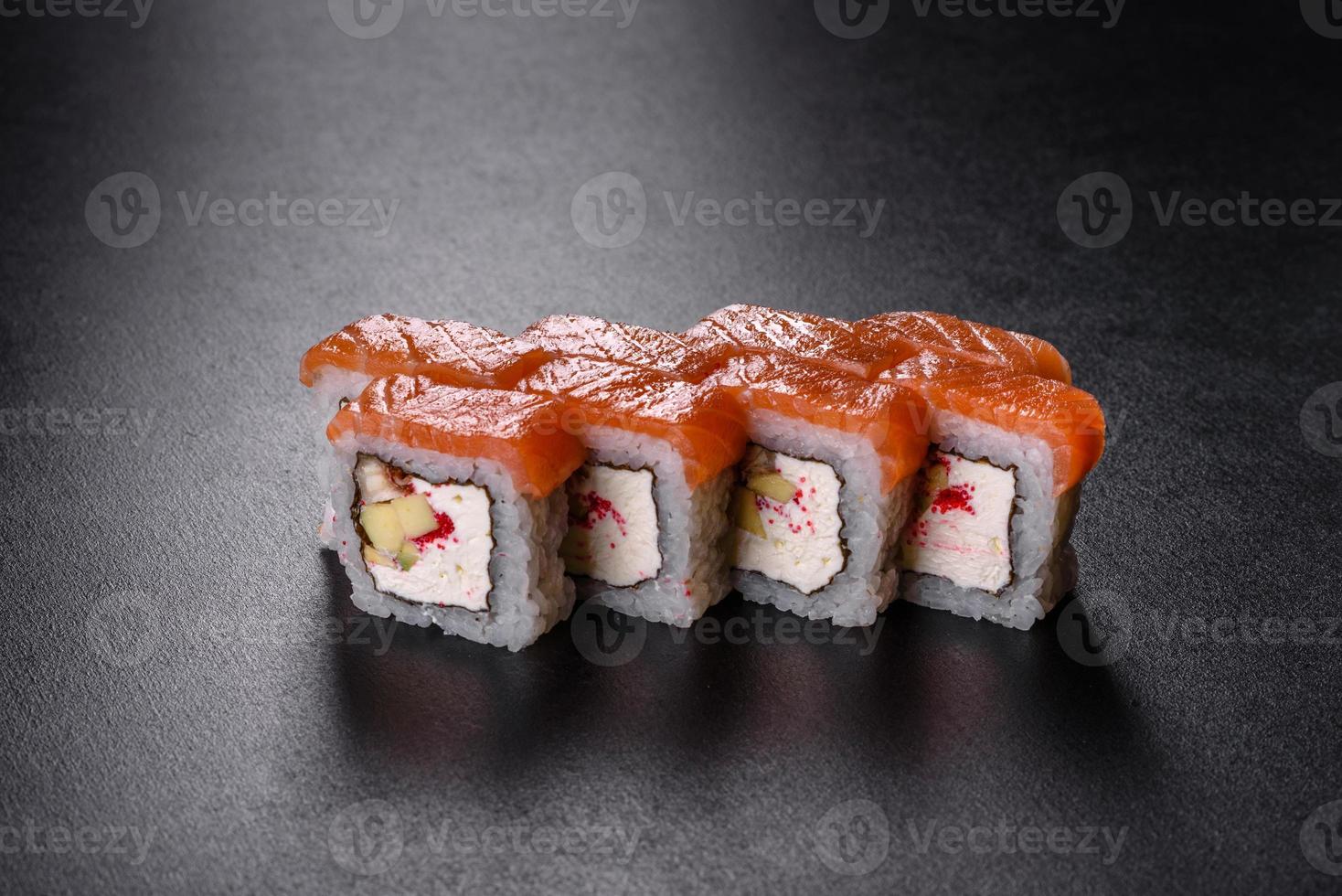 Rouleau de sushi frais délicieux traditionnel sur fond noir photo