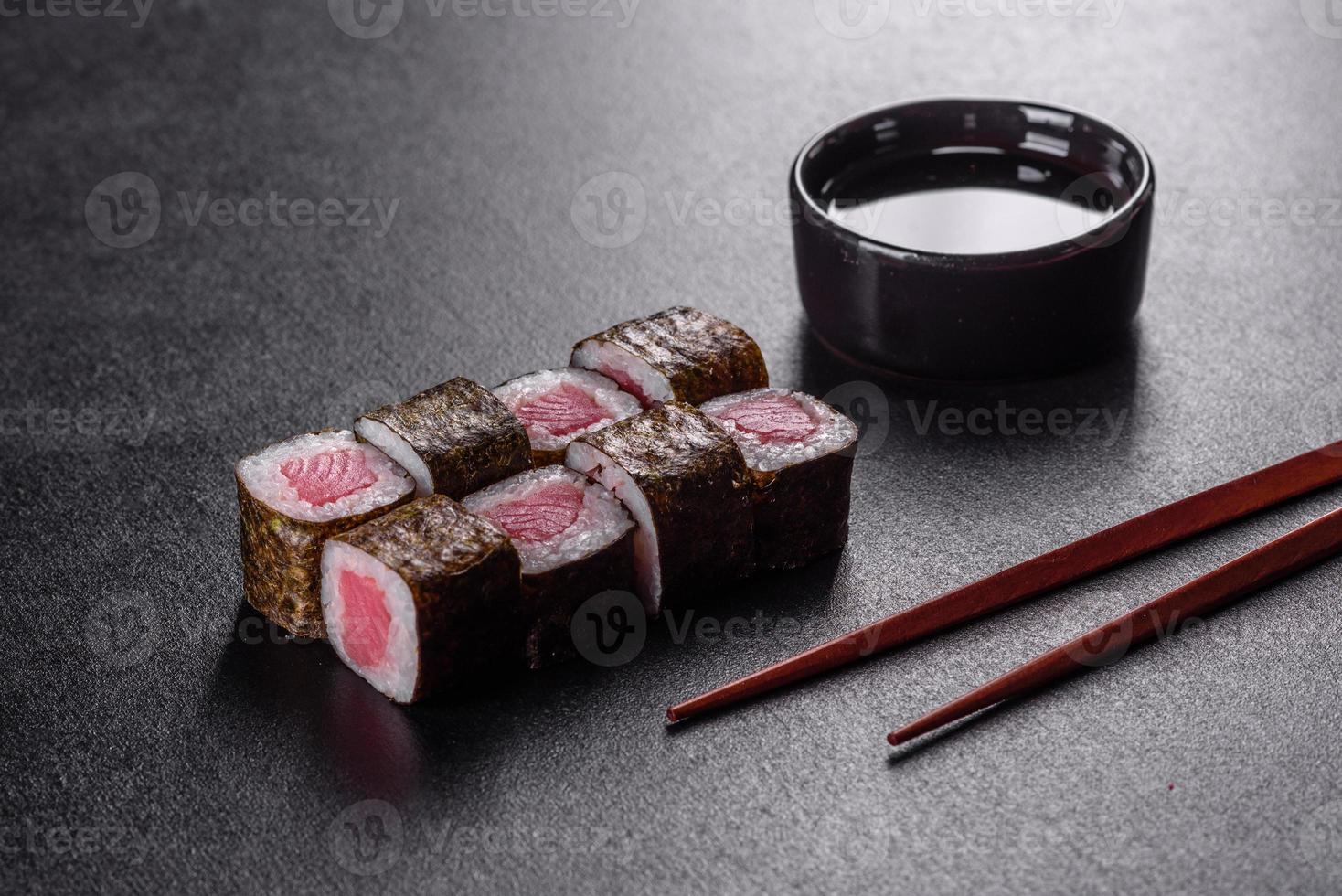 Rouleau de sushi frais délicieux traditionnel sur fond noir photo