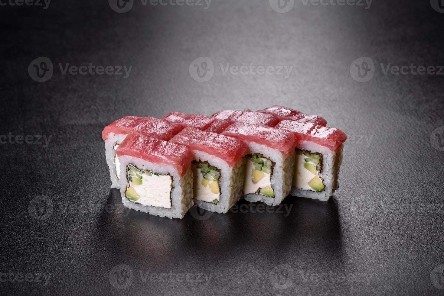Rouleau de sushi frais délicieux traditionnel sur fond noir photo