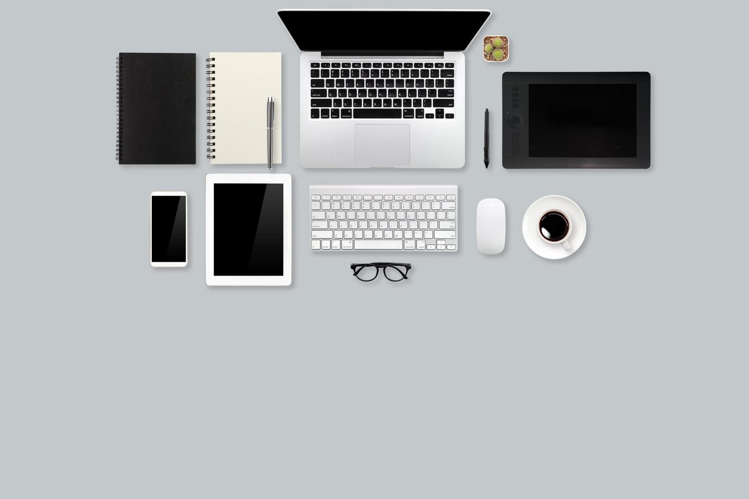vue de dessus de table d'espace de travail moderne avec ordinateur portable, tasse à café, fournitures de bureau et mobile sur fond gris photo