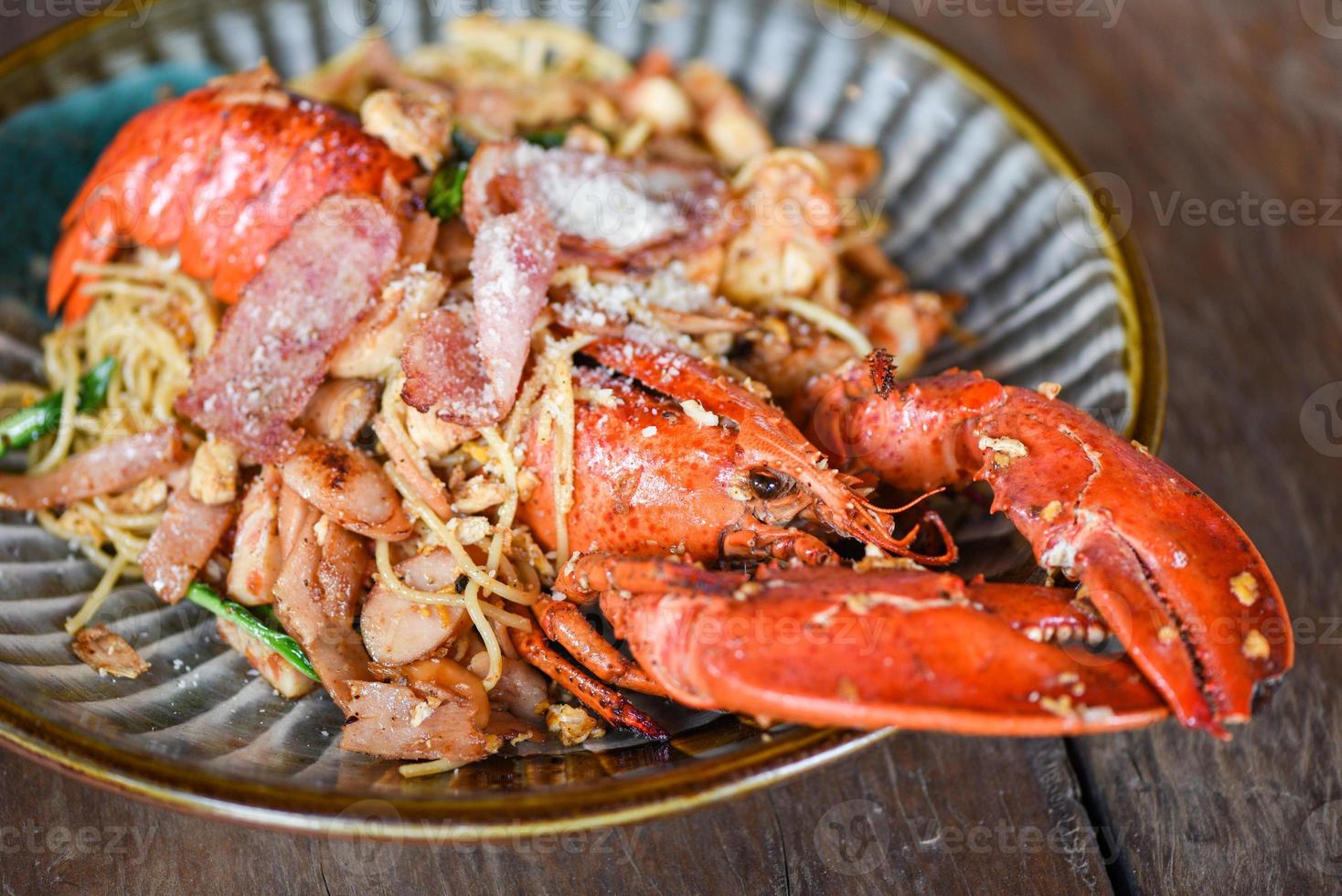 assiette de fruits de mer crustacés avec homard dîner nourriture cuite - homard grillé saucisse jambon légumes et fromage spaghetti fruits de mer sur table en bois photo