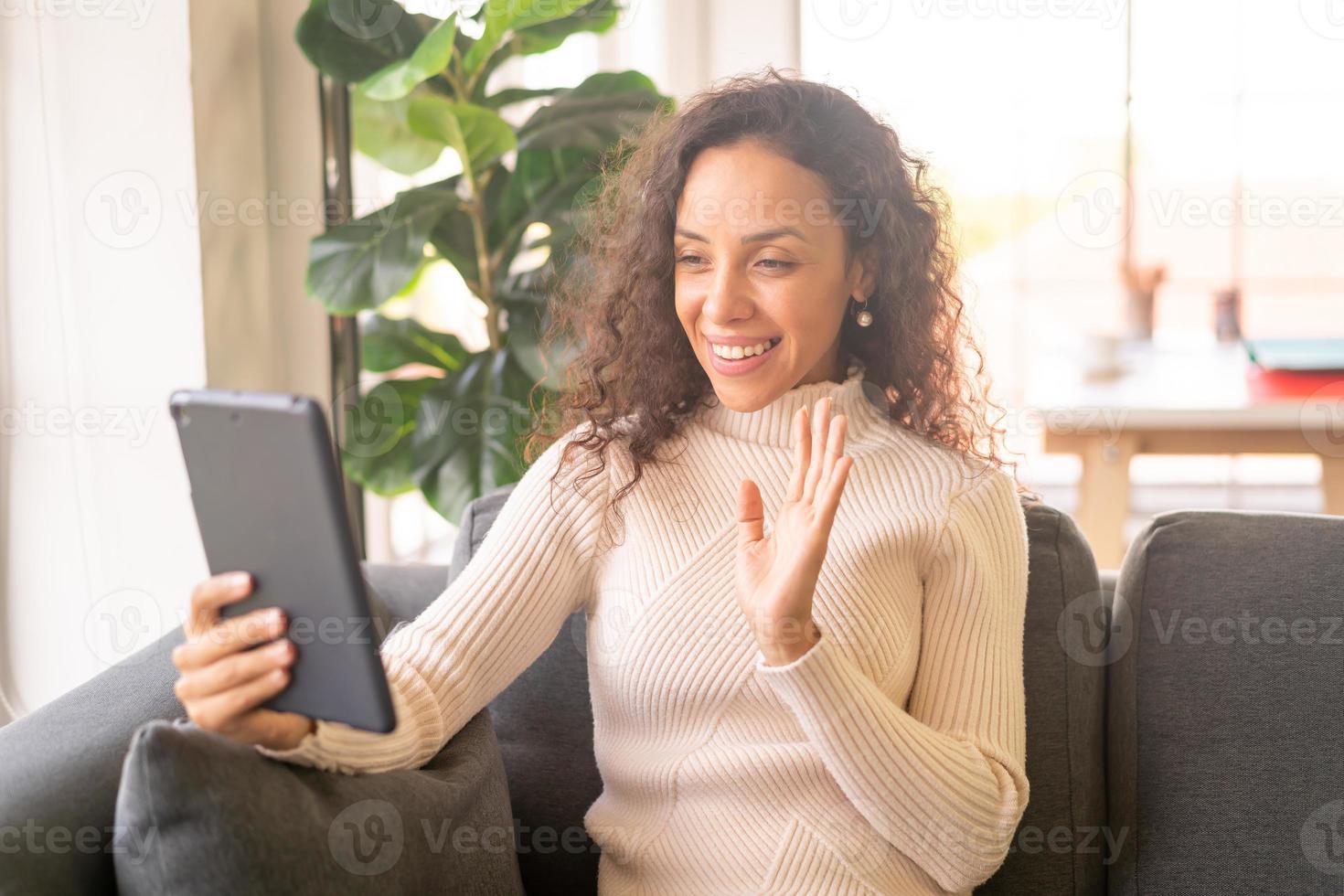 vidéoconférence femme latine sur tablette avec un sentiment de bonheur photo