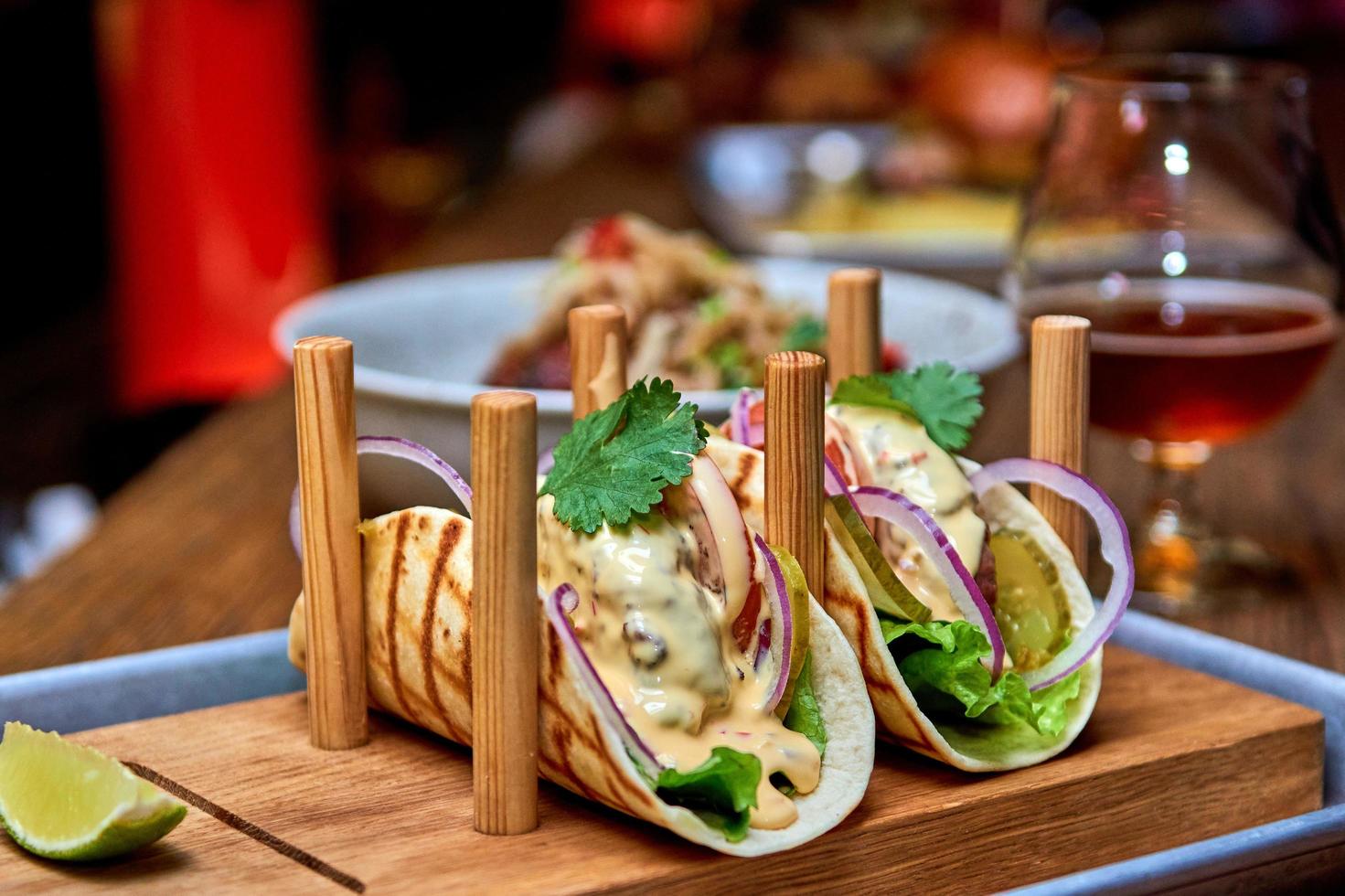 tacos mexicains traditionnels au porc avec bœuf, tomates, avocat, piment dans une tortilla de maïs jaune photo