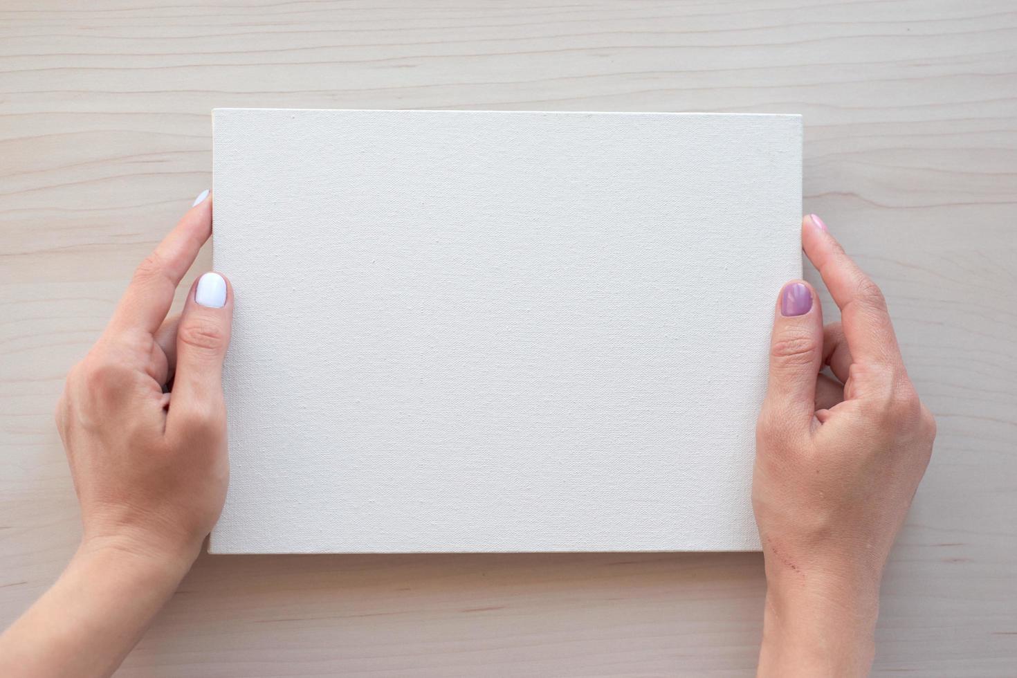 tableau blanc avec les mains pour l'espace de copie. fournitures de bureau scolaire sur fond en bois. concept de retour à l'école. vue de dessus prête pour votre conception photo