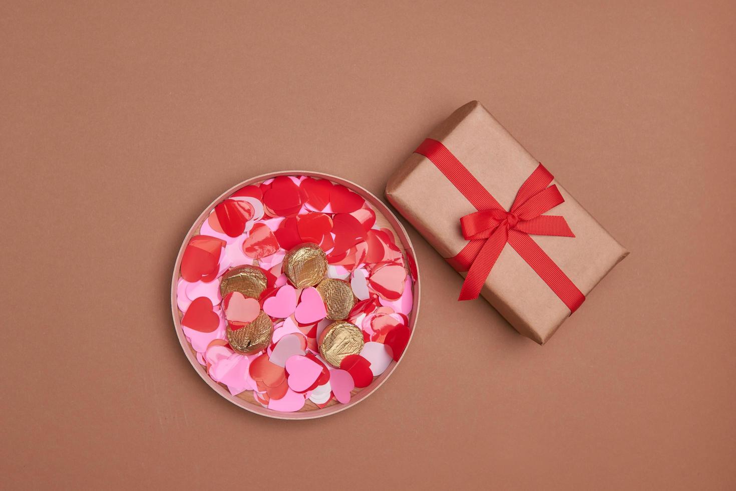 composition de la Saint-Valentin. coffret, confettis, enveloppe carte postale avec coeur rouge sur fond pastel photo