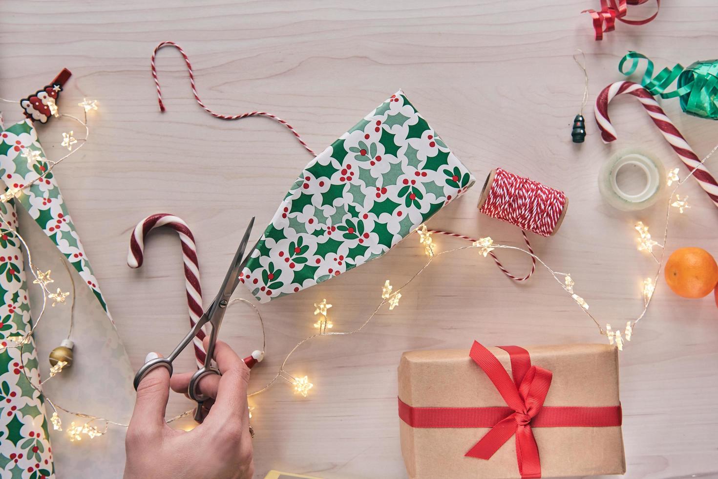 composition de noël. coffrets cadeaux, emballage de cadeaux avec papier et ruban, lumières, cannes de bonbon sur fond en bois. holdiay bricolage décoration de la maison à la main. hiver, mise à plat du nouvel an, vue de dessus photo