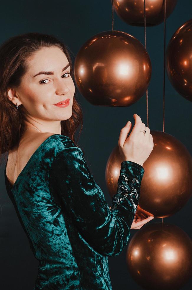 jolie fille en robe de luxe, jouant avec des boules d'or, concept de nouvel an ou de noël photo