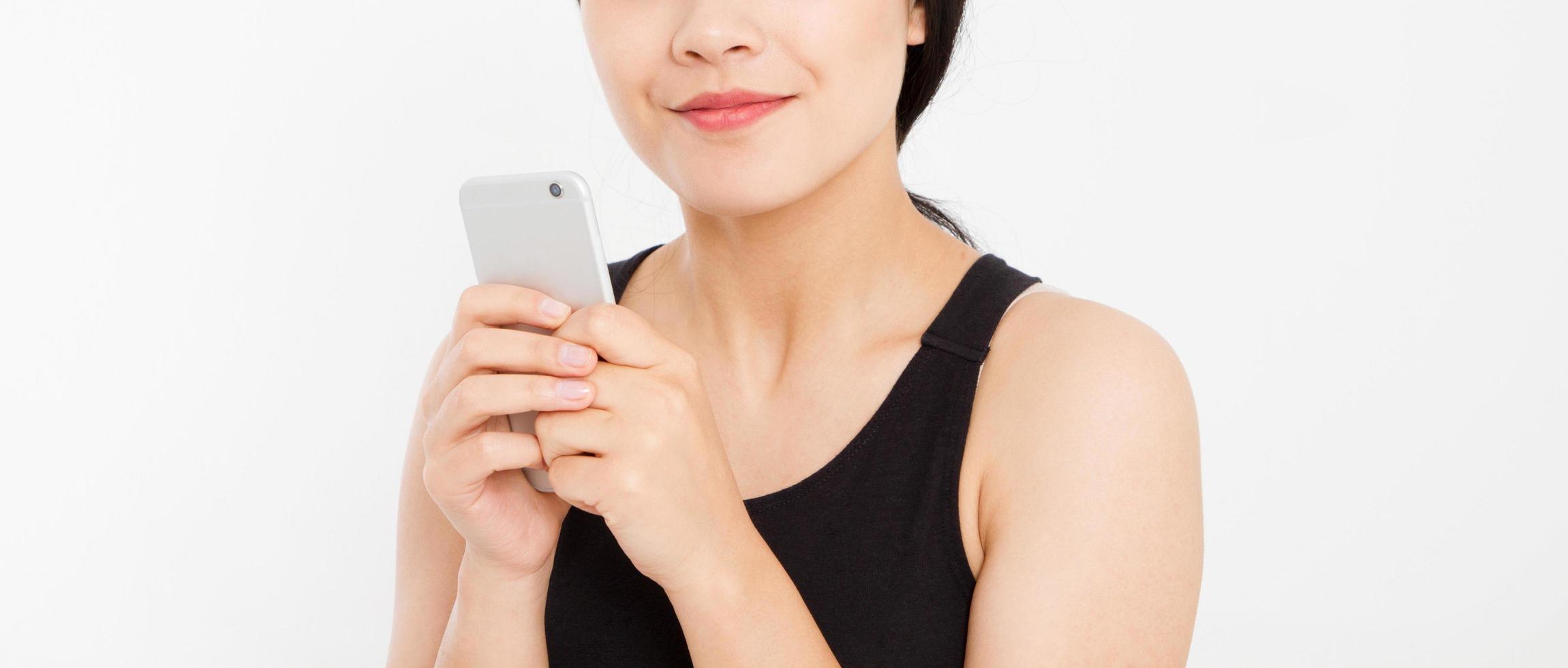 femme textos. gros plan jeune heureuse belle femme japonaise asiatique. fille regardant un téléphone portable isolé sur fond blanc. expression de visage positif émotion humaine. espace de copie. photo