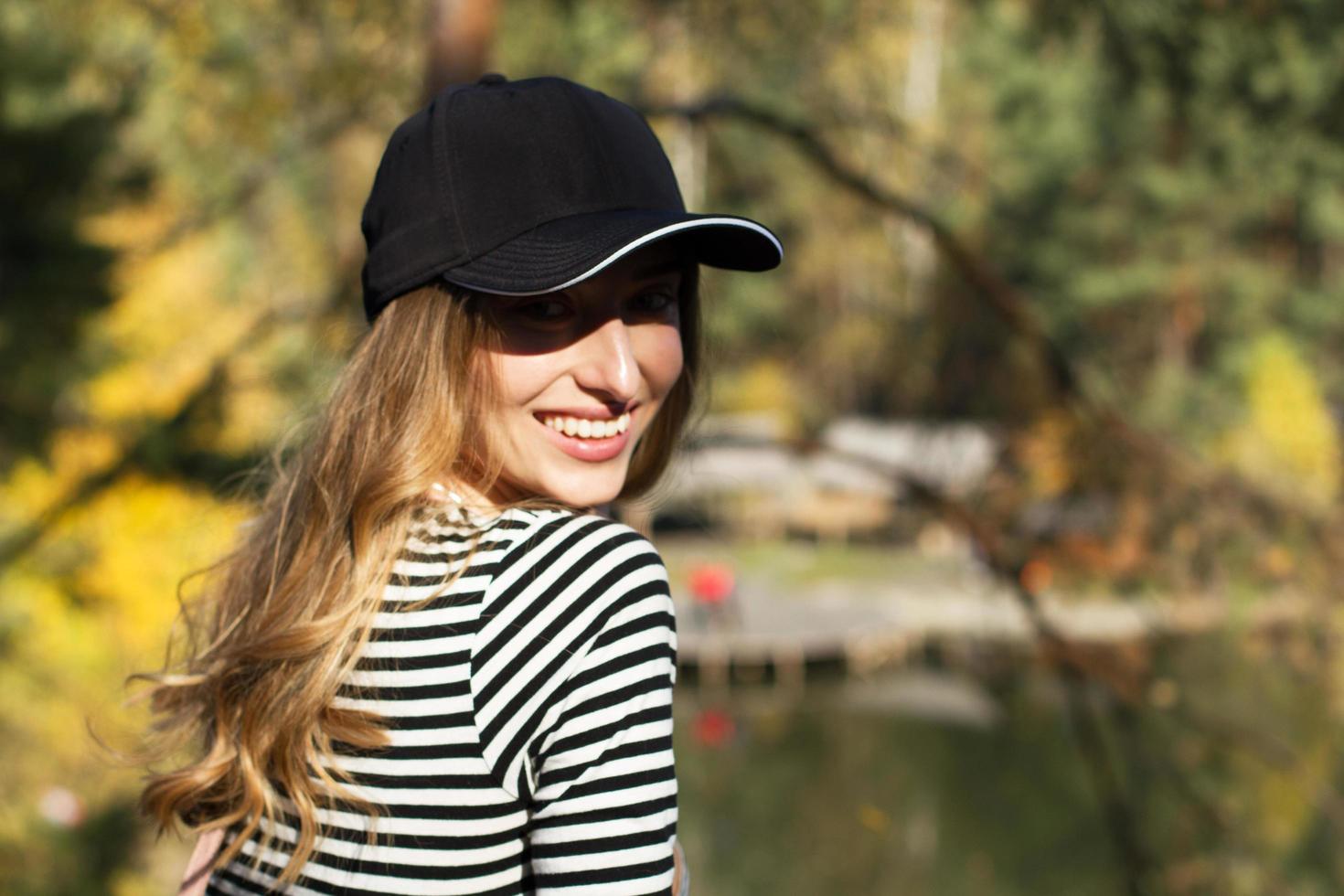 profiter de la nature. jeune femme en blazer noir profitant de l'air frais dans la forêt verte. portrait d'une femme caucasienne souriante photo