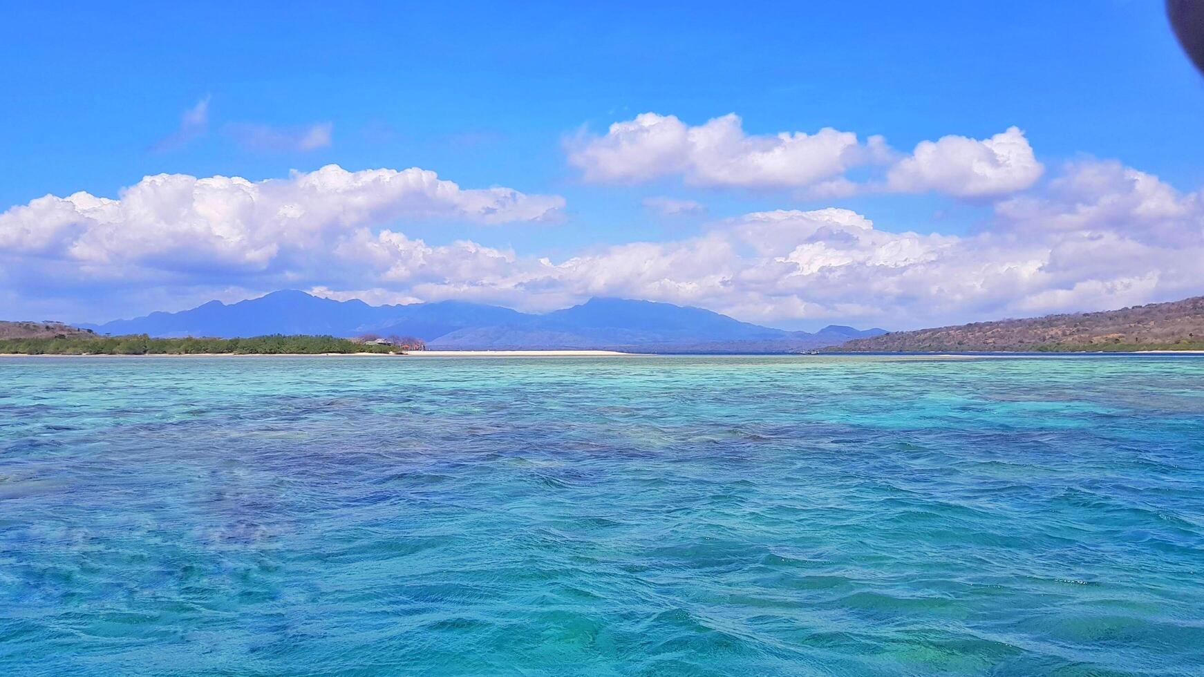 mer claire avec un fond clair de colline et de ciel photo