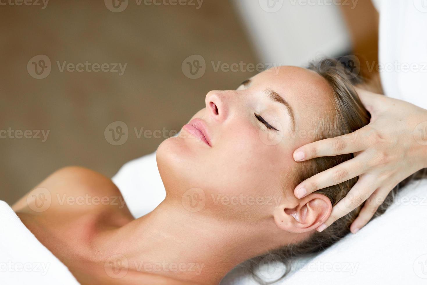 jeune femme recevant un massage de la tête dans un centre de spa. photo