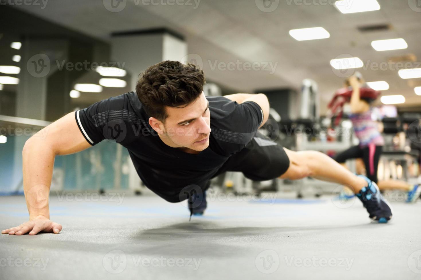 homme séduisant doin pompes dans la salle de gym photo