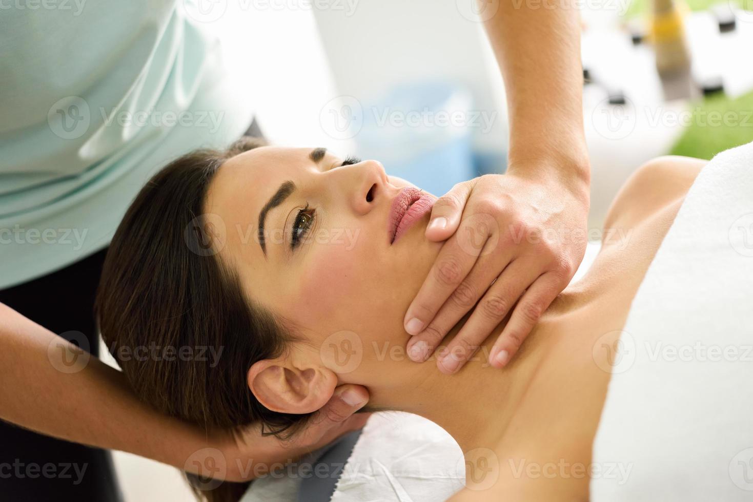 jeune femme recevant un massage de la tête dans un centre de spa. photo