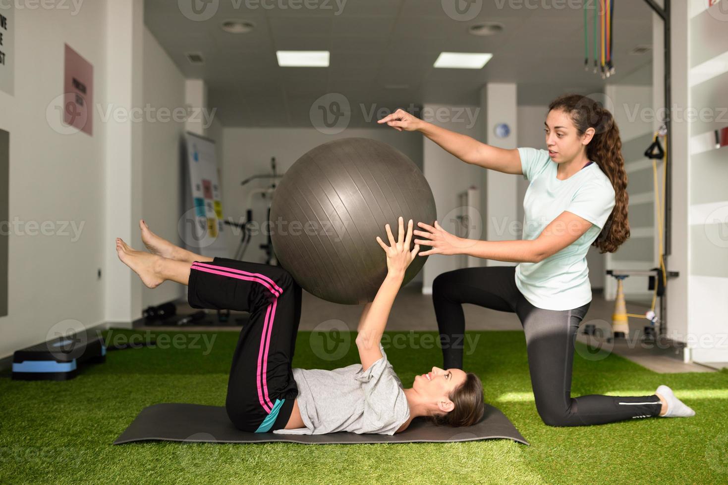 physiothérapeute aidant une jeune femme de race blanche à faire de l'exercice photo