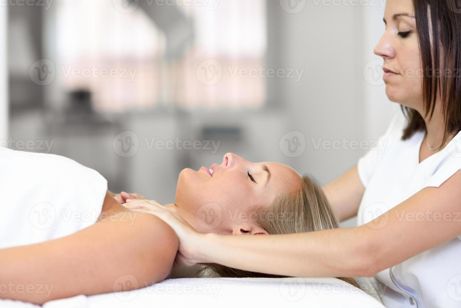 jeune femme recevant un massage de la tête dans un centre de spa. photo