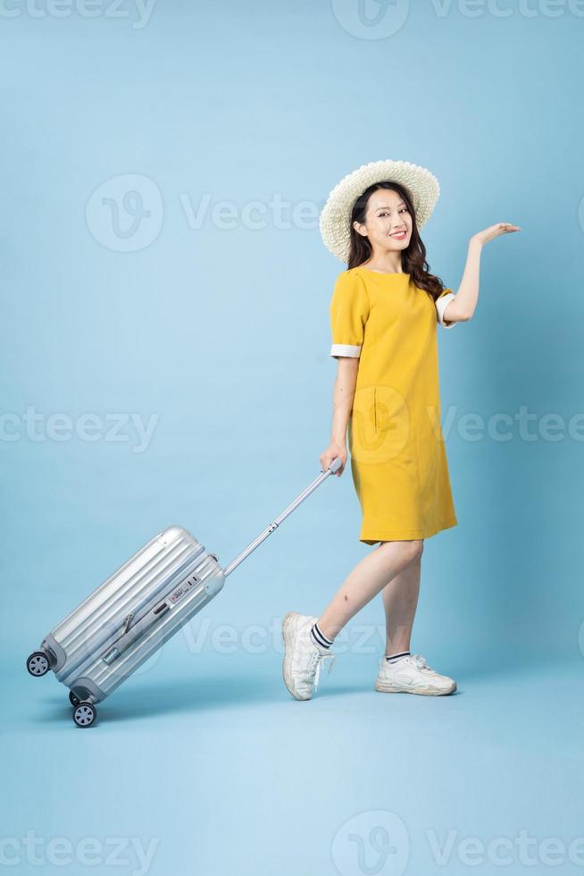Image de voyage fille asiatique, isolé sur fond bleu photo