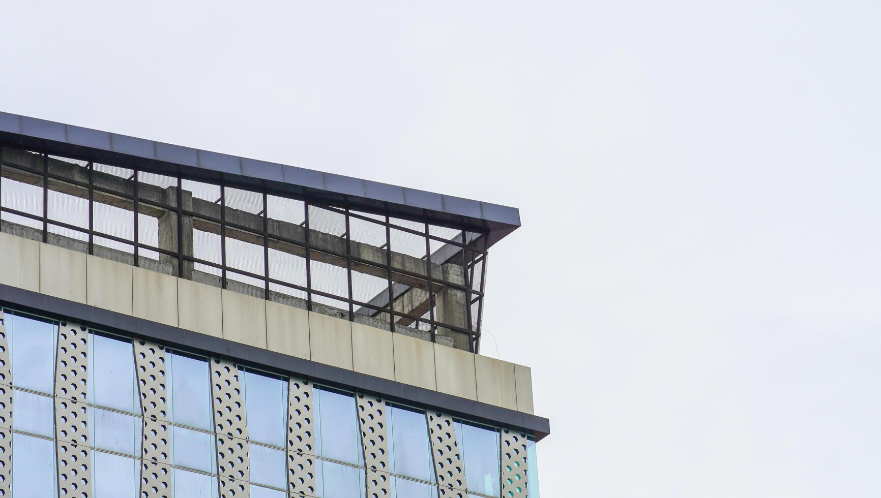 un gratte-ciel qui a de nombreux matériaux en verre avec un fond de ciel bleu. le haut bâtiment de la zone urbaine. photo