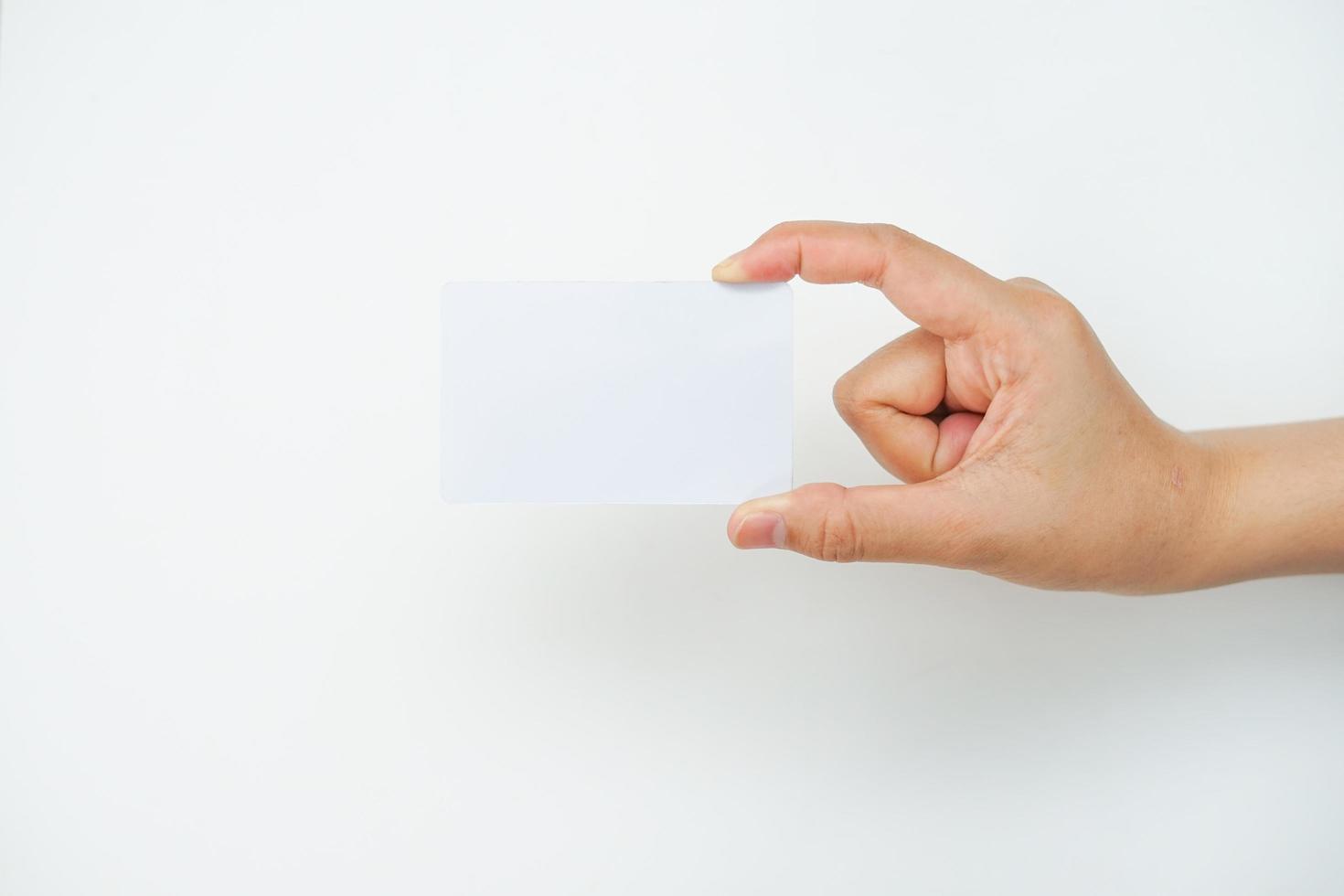 une main droite tient un espace blanc vide sur fond blanc. une maquette de carte adaptée à une utilisation commerciale ou de maquette d'identité. photo