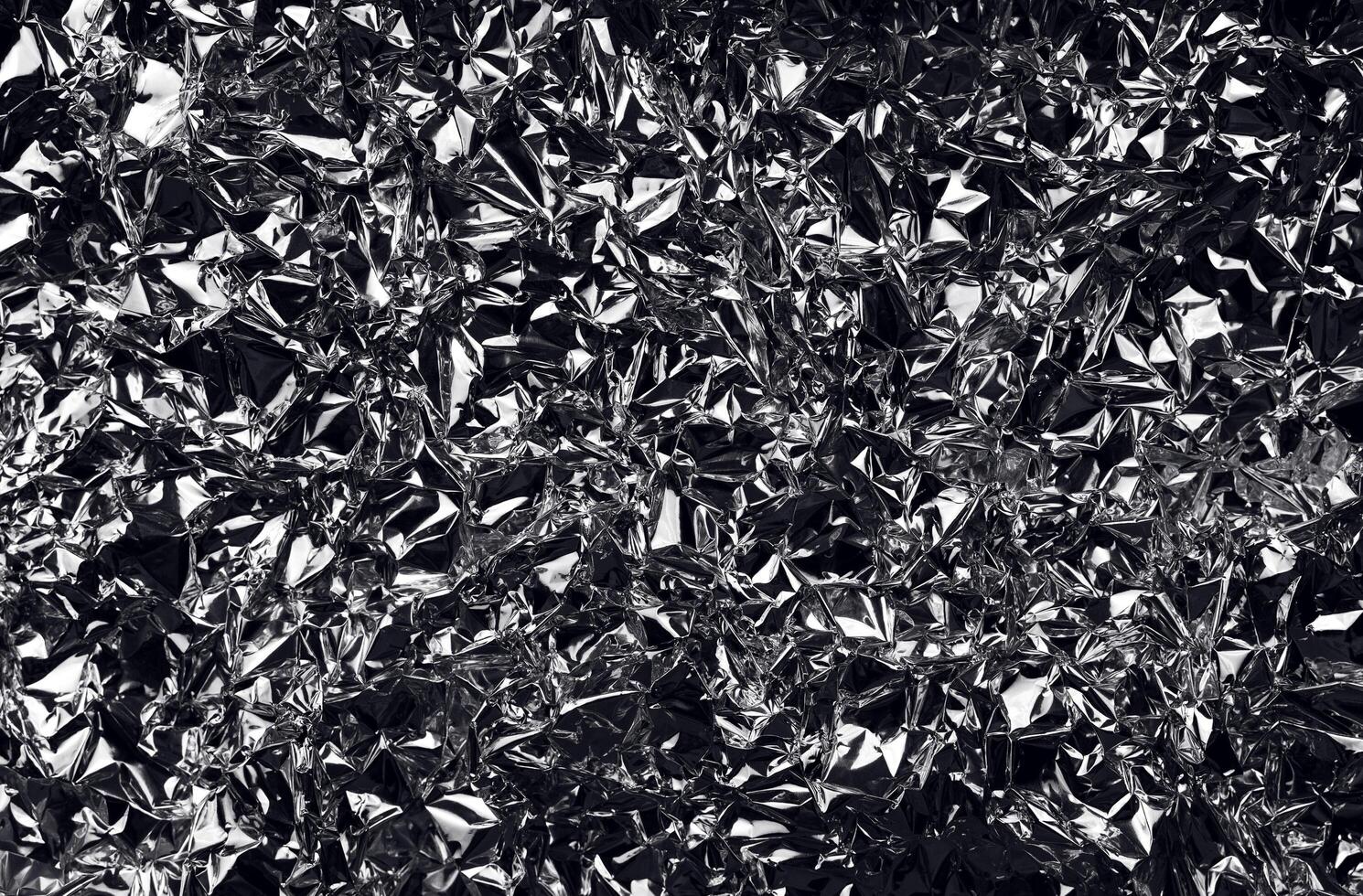 fond de papier d'aluminium froissé. feuille d'argent brillant froissé pour la décoration. élément de design créatif en forme minable. surface de texture abstraite du papier d'emballage. photo