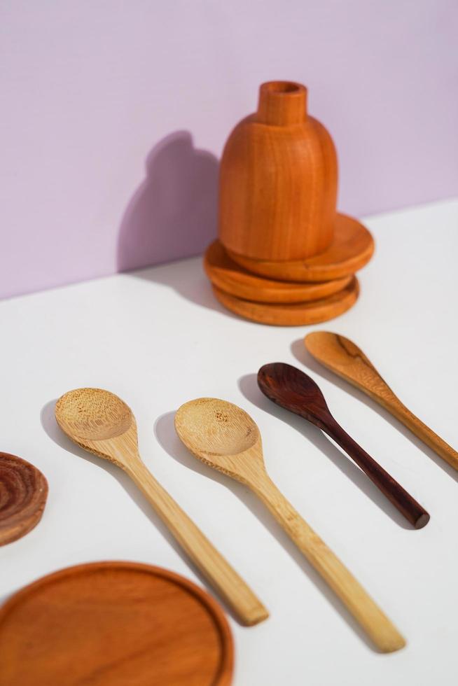 ensemble de divers ustensiles en bois, comprenant des sets de table, des cuillères et une bouteille décorative. une prise de vue en studio des ustensiles organiques. adapté à la publicité. photo