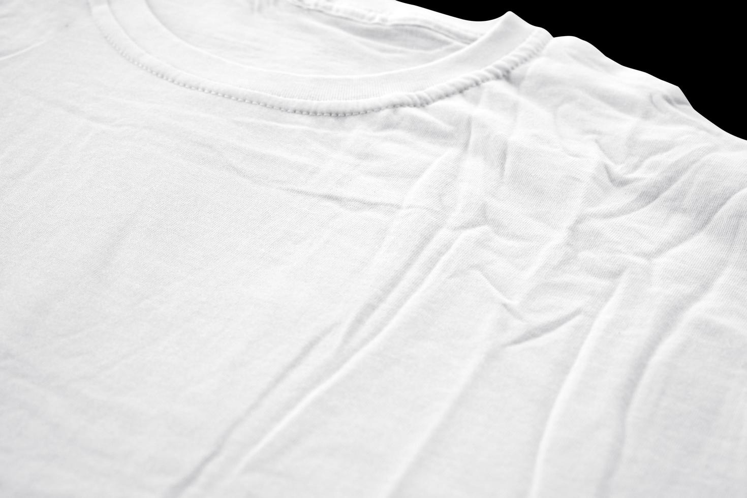 détails en tissu de t-shirt blanc pour les maquettes de badges. t-shirt uni avec fond noir pour un aperçu du design. photo