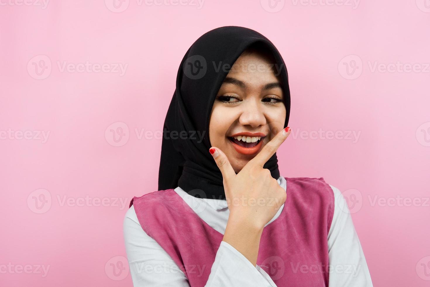 gros plan sur une belle jeune femme musulmane regardant un espace vide, présentant quelque chose, isolé photo