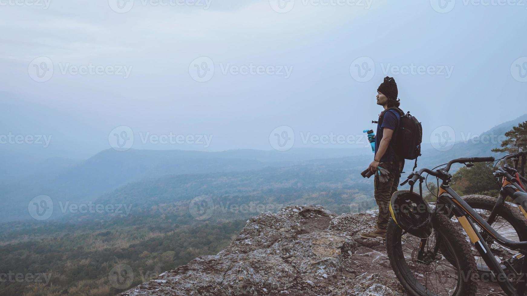 les hommes asiatiques voyagent dans la nature. voyage détendez-vous faire du vélo dans la nature sauvage. tenez-vous sur la ligne. dans la prairie dans les bois. Thaïlande photo