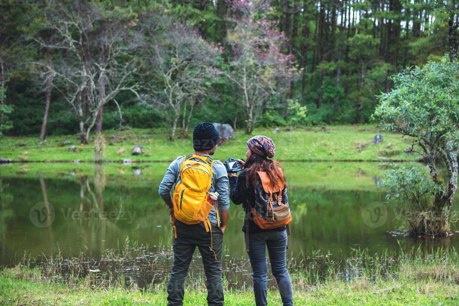 couples asiatiques, détendez-vous en vacances. voyage nature prenant des photographies rose sakura. photo