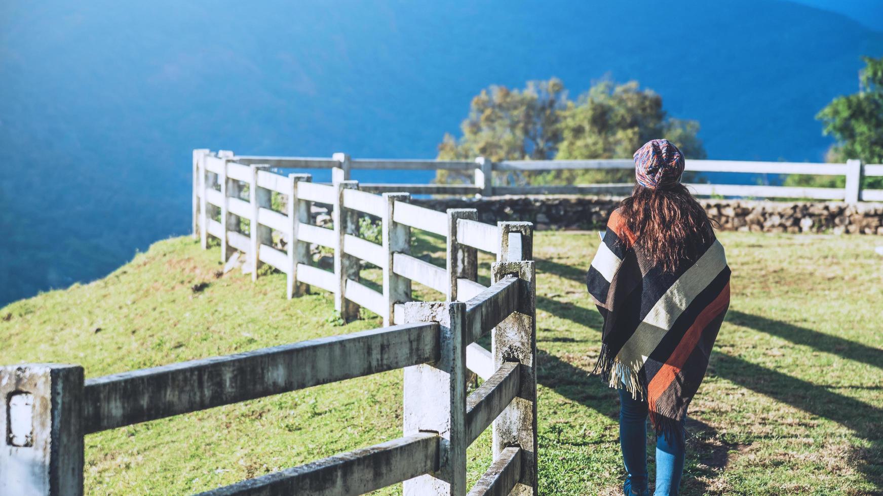 Jeune femme se détendre pendant les vacances, elle marche vers la belle sur le point de vue sur la montagne.à la ferme de moutons doi pha tang en thaïlande photo