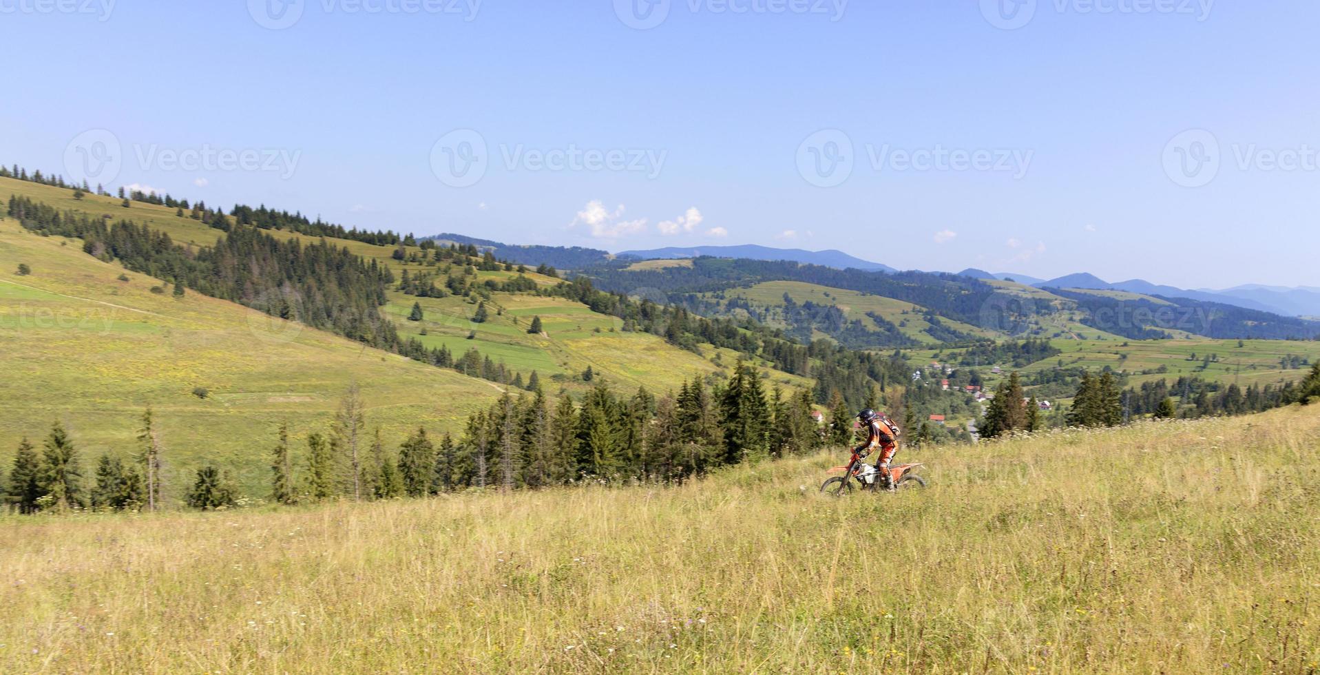 motocycliste descend la pente des montagnes des Carpates photo