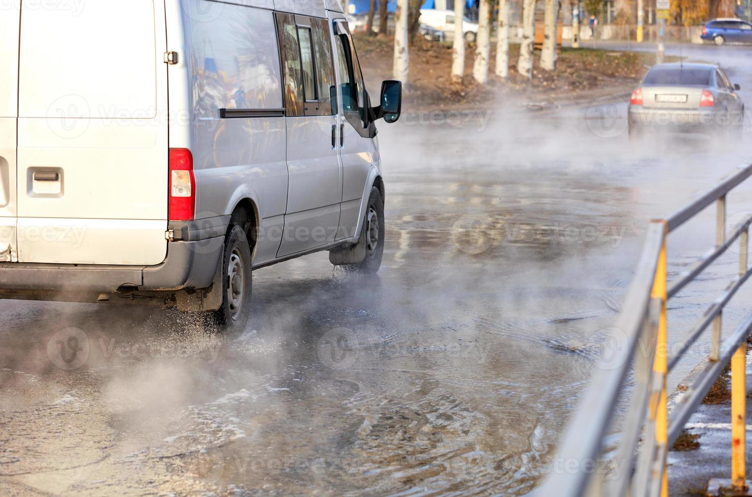 la route a été inondée d'eau chaude après la percée de la canalisation de chauffage de la ville. photo