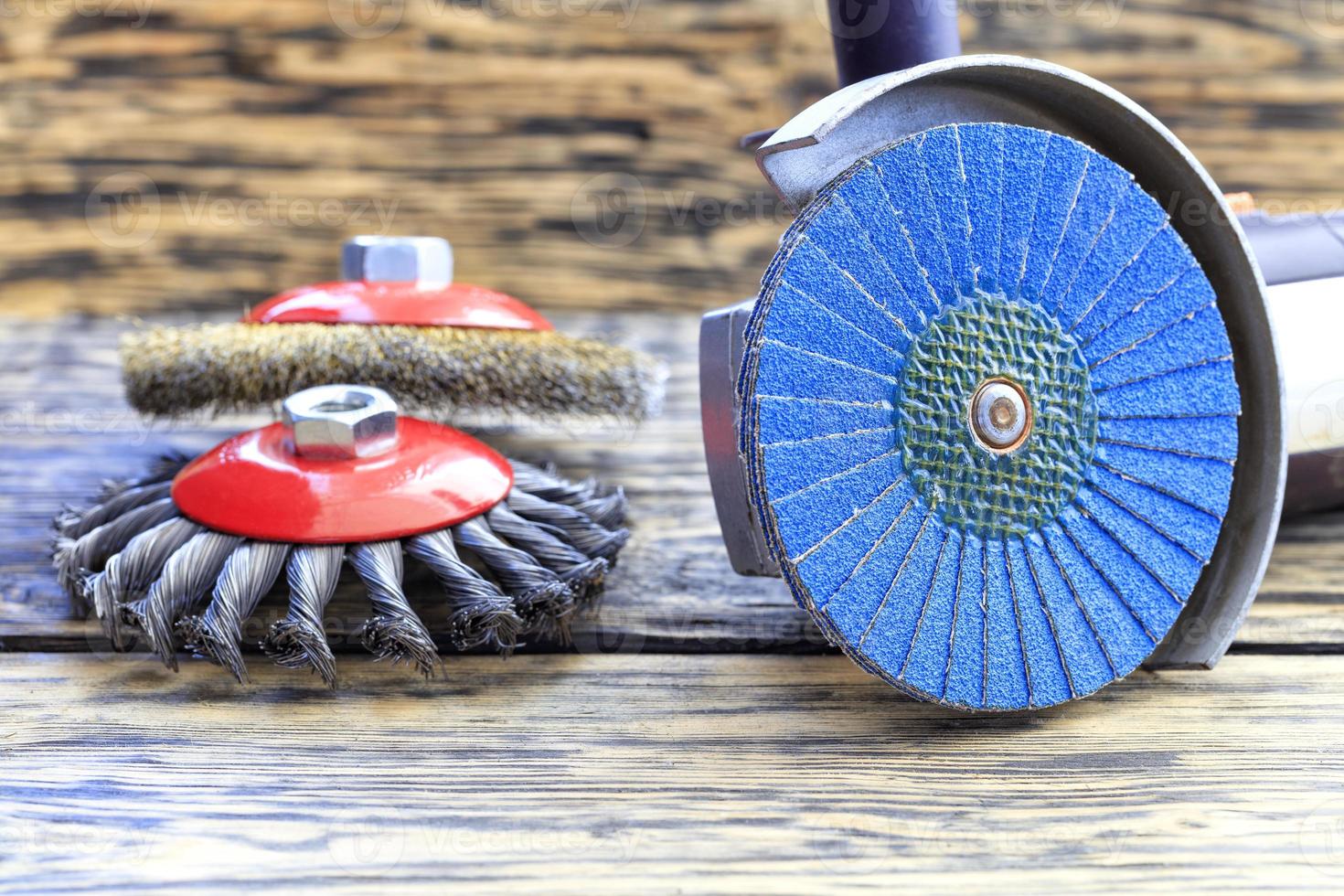 meuleuse d'angle avec brosses à disque de meulage se trouve sur le fond d'une table en bois. photo