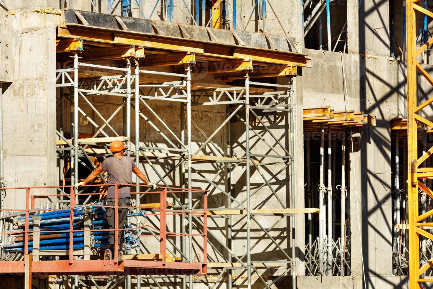 un constructeur installe un système d'échafaudages et de supports métalliques dans un nouveau bâtiment. photo