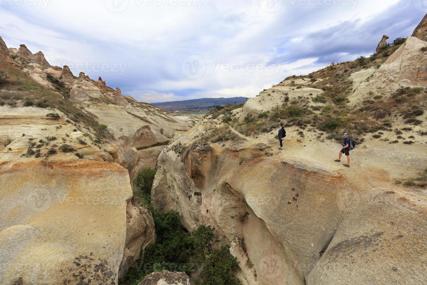 un jeune couple de touristes se tient au bord d'un canyon en cappadoce photo